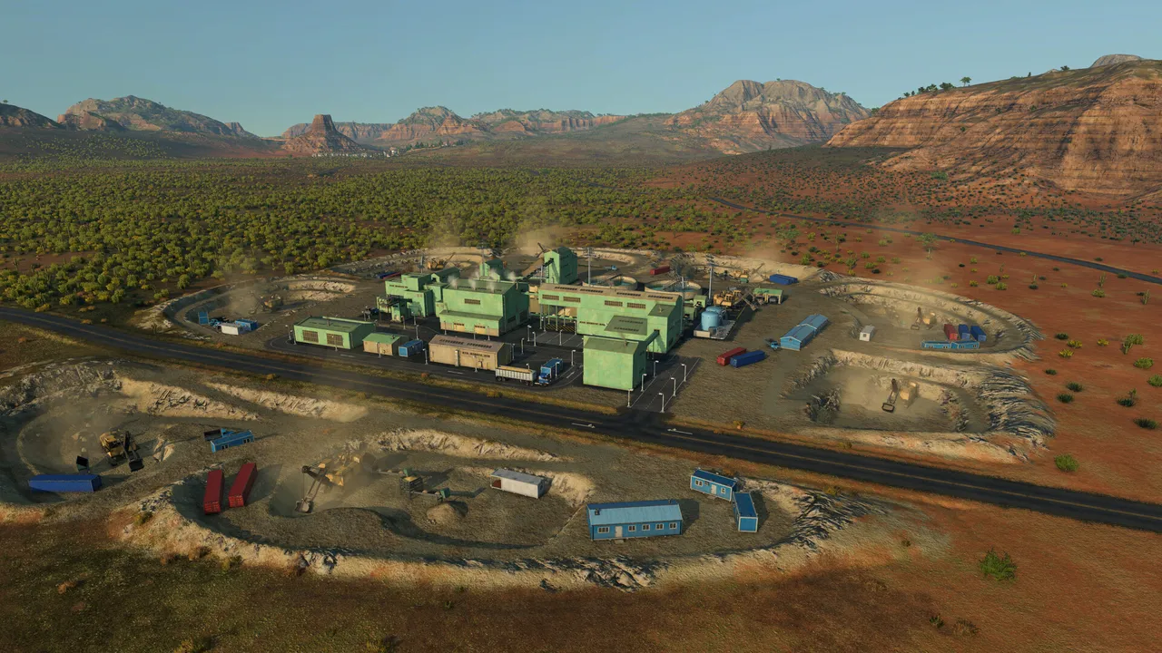 A mine site with pale green buildings among red desert rock and dirt roads